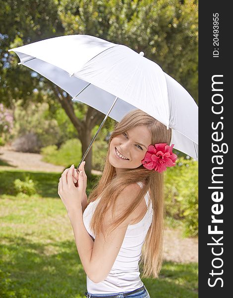 Beautiful blonde girl  in park with white umbrella