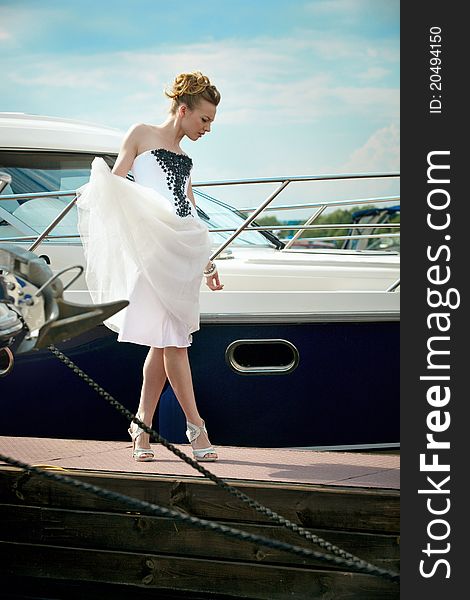 A girl in a summer dress near the boat, sunny day. A girl in a summer dress near the boat, sunny day