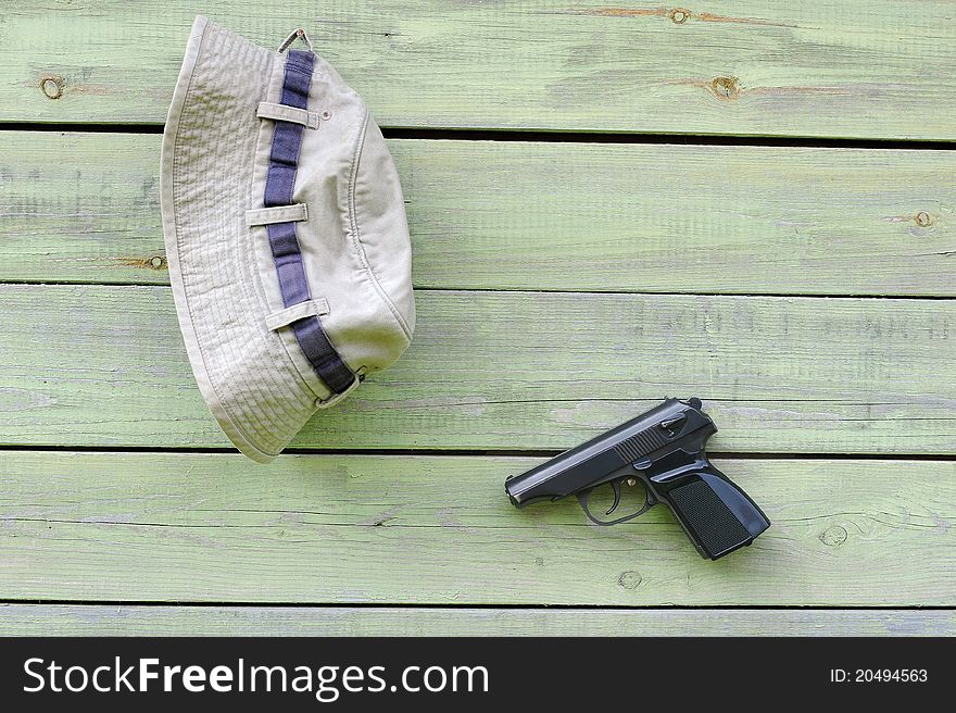 Hat and pistol on shabby wall of the barn. Hat and pistol on shabby wall of the barn