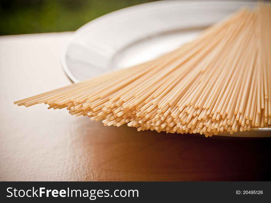 A plate of dried spaghetti pasta shot in natural sunlight