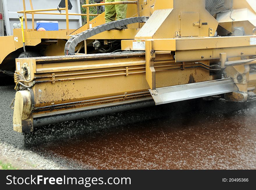 Gravel spreader at work preparing road for re-surfacing