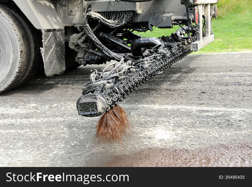 Truck sprays oil on road to prepare it for resurfacing