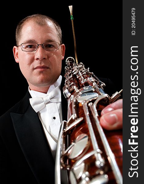 Caucasian male holds his bassoon with a serious expression on his face in the studio. Caucasian male holds his bassoon with a serious expression on his face in the studio.