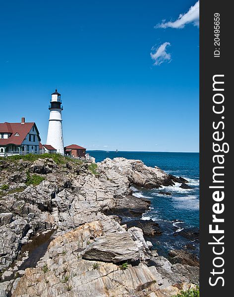 White old lighthouse with small house of its keeper