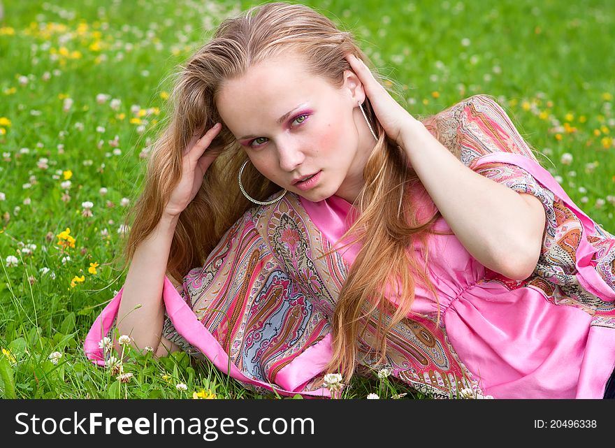 Portrait of a beautiful young woman on the grass in summer. Portrait of a beautiful young woman on the grass in summer