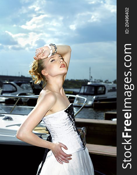 A girl in a summer dress near the boat, sunny day. A girl in a summer dress near the boat, sunny day