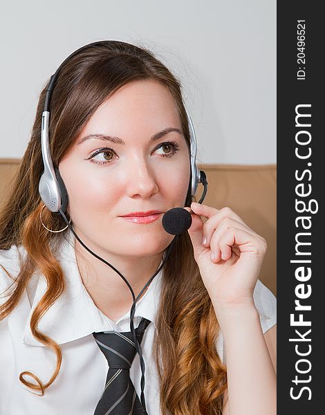 Business woman talking in a tie with headphones in the office. Business woman talking in a tie with headphones in the office