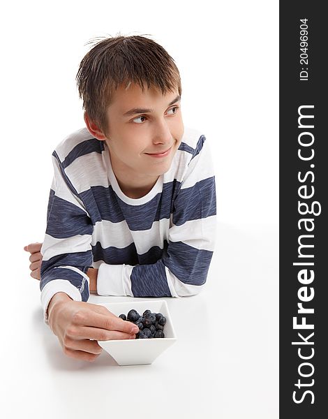 Boy with a bowl of berries. He is looking sideways, suitable for message. White background. Boy with a bowl of berries. He is looking sideways, suitable for message. White background.