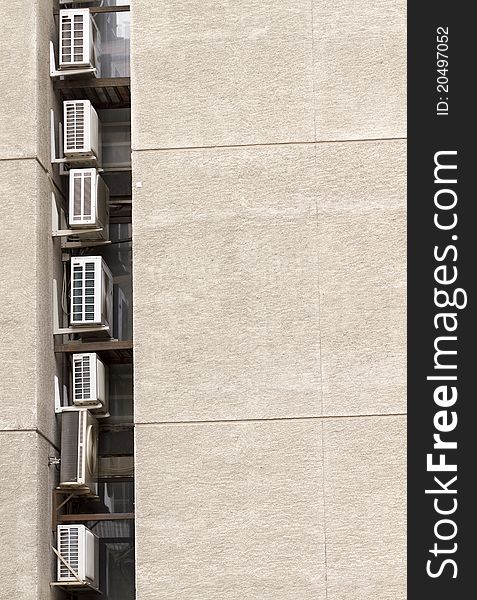 Column of air conditioners on a building wall