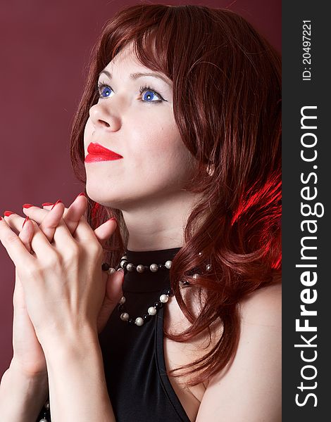 Praying woman on red burgundy background