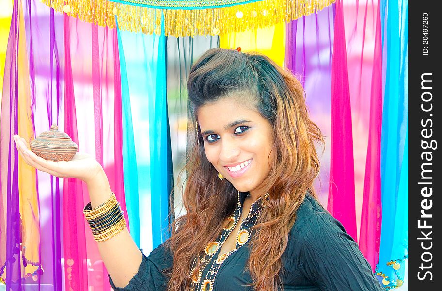 Young Pakistani model holding a traditional indian lamp on her hands. Young Pakistani model holding a traditional indian lamp on her hands