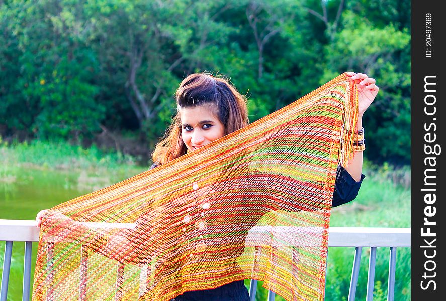 A young Pakistani model holding a traditional indian scarf and posing in the outdoors. A young Pakistani model holding a traditional indian scarf and posing in the outdoors.