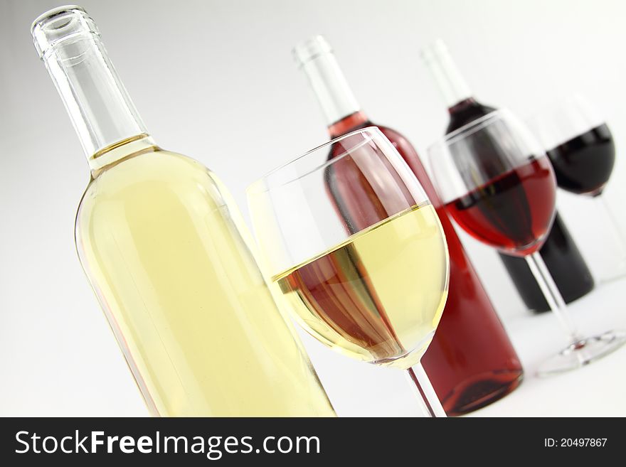 Three colors of wine in bottles and glasses