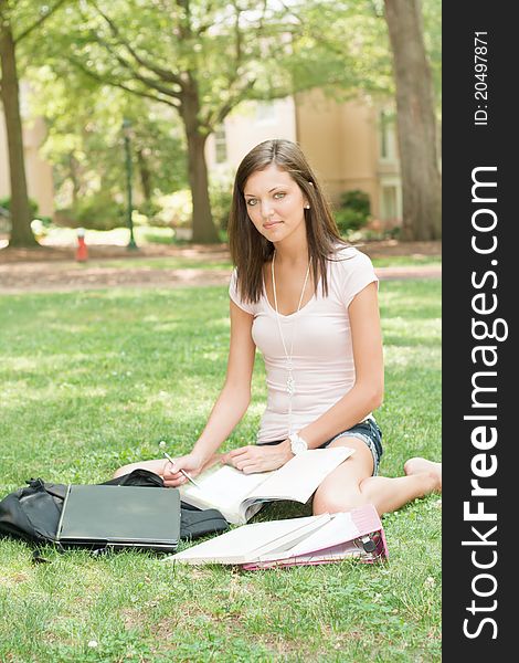 A pretty young college or high school age girl with study materials. A pretty young college or high school age girl with study materials