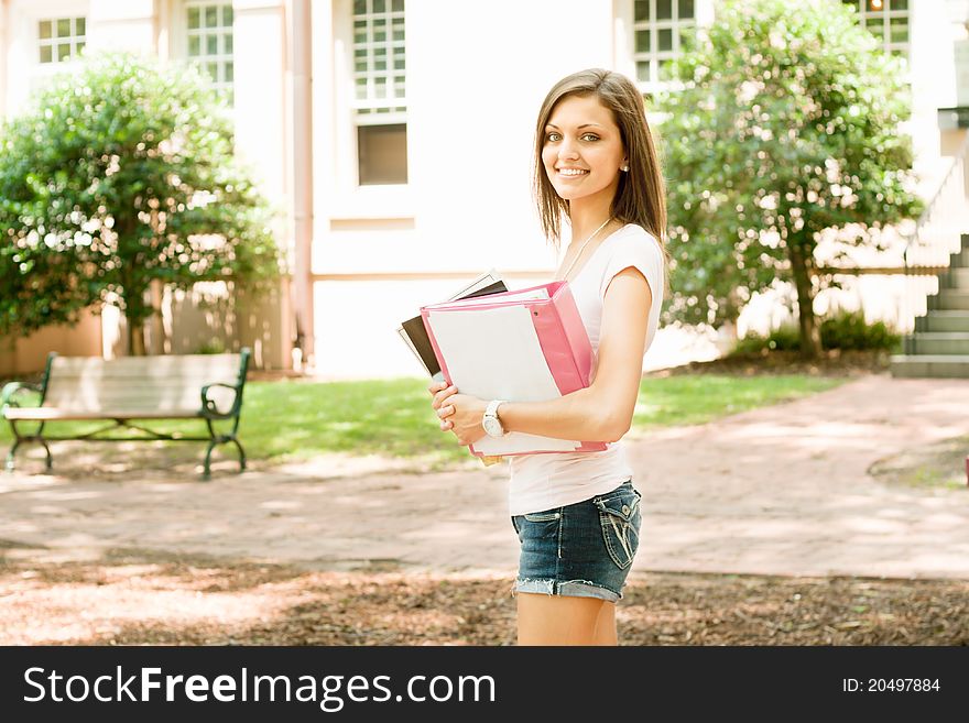 A pretty young college or high school age girl with study materials. A pretty young college or high school age girl with study materials