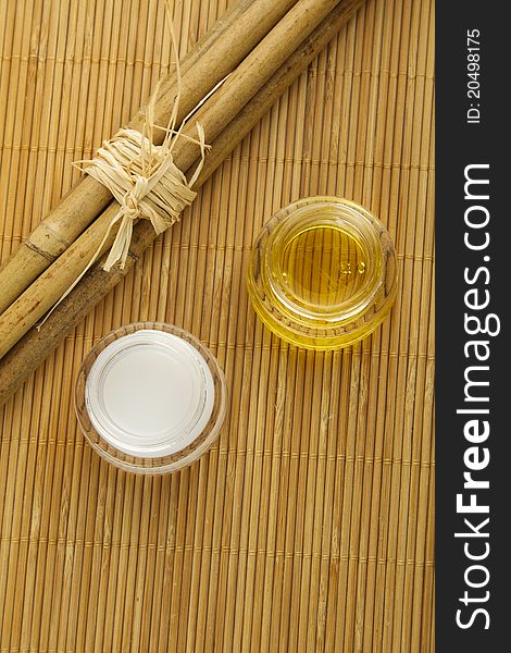 Two cans of cream and bamboo sticks on a wooden mat. Two cans of cream and bamboo sticks on a wooden mat