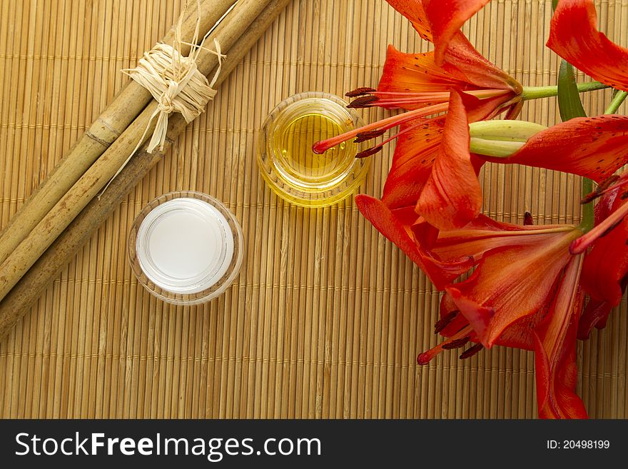 Two cans of cream flowers and bamboo sticks on a wooden mat. Two cans of cream flowers and bamboo sticks on a wooden mat