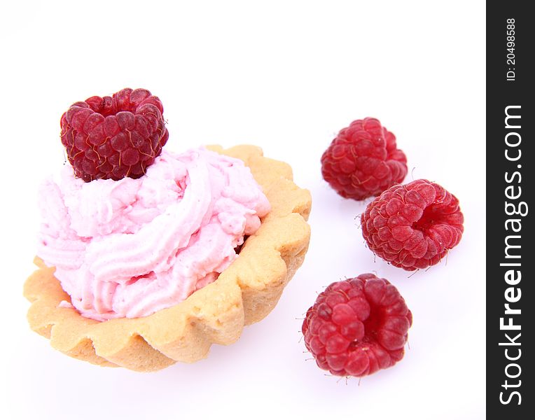 Tartlet with whipped cream and a raspberry on a white background