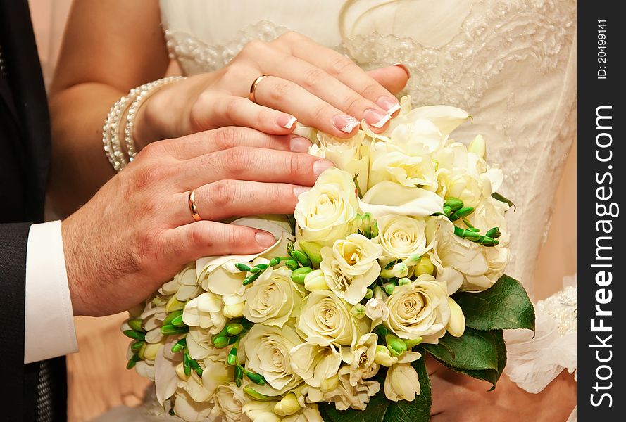 Hands on a bouquet of newly-weds in the registry office. Hands on a bouquet of newly-weds in the registry office
