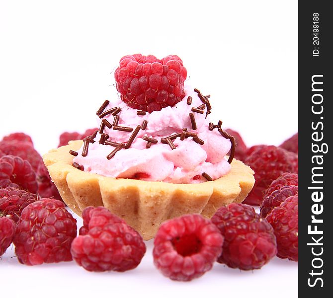 Tartlet with whipped cream and raspberries on a white background