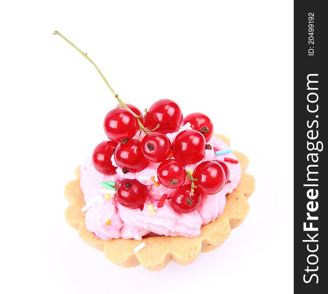 Tartlet with whipped cream, red currants and sprinkles on a white background