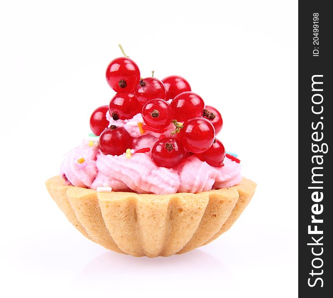 Tartlet with whipped cream, red currants and sprinkles on a white background