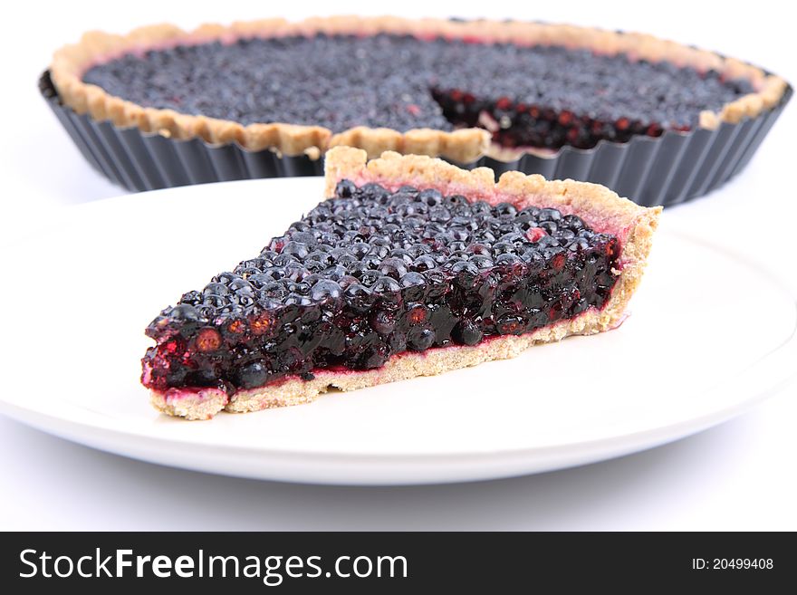 Blueberry Tart: a portion on a plate and in a tart pan on a white background