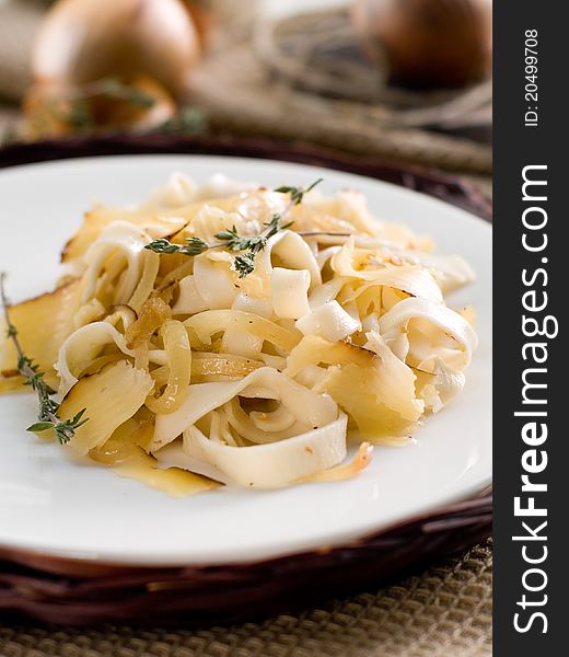 Tagliatelli pasta with onion, thyme and cheese. Selective focus