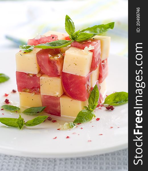 Tomato and cheese appetizer with olive oil and basil. Selective focus