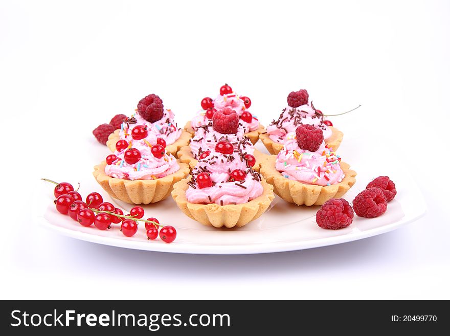 Tartlets with whipped cream, fruits and sprinkles - raspberries and redcurrants