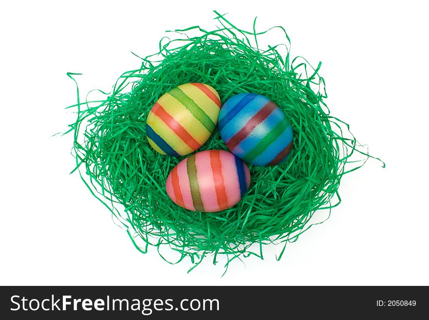 Colored eggs on artificial grass. Isolated on a white background. Colored eggs on artificial grass. Isolated on a white background.