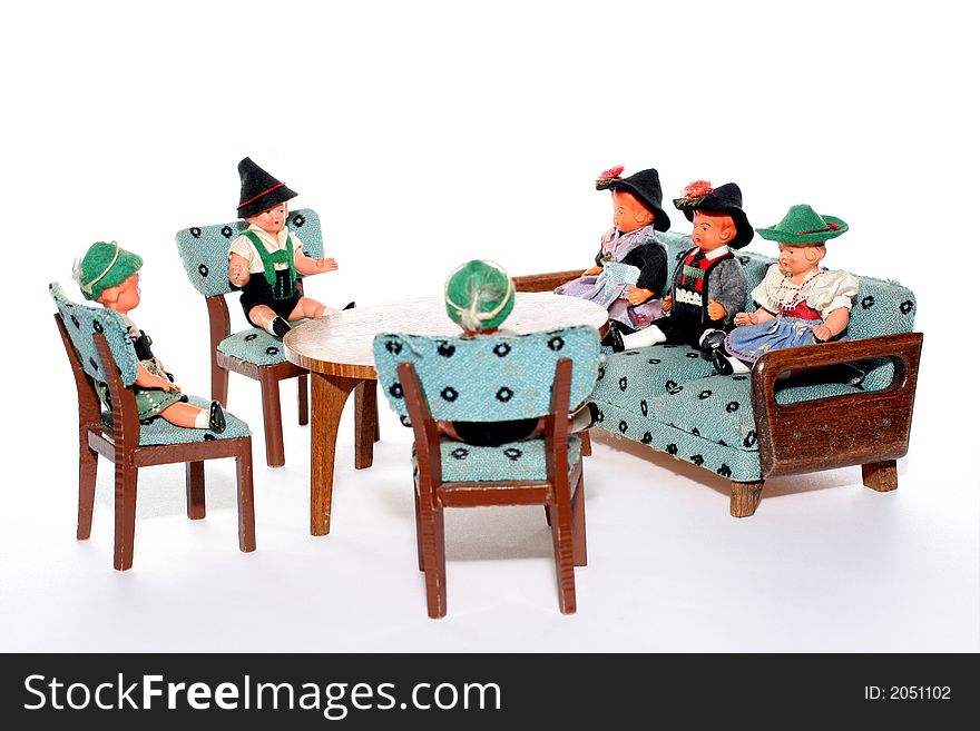 6 dolls in traditional European (I think they are Austrian but not sure) dresses sitting on chairs and couch round a table (old hand made furniture). 6 dolls in traditional European (I think they are Austrian but not sure) dresses sitting on chairs and couch round a table (old hand made furniture)