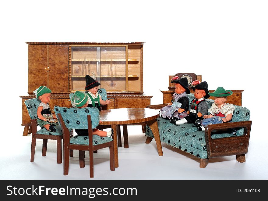 6 dolls in traditional European (I think they are Austrian but not sure) dresses sitting on chairs and couch round a table (old hand made furniture) with racks on the background. 6 dolls in traditional European (I think they are Austrian but not sure) dresses sitting on chairs and couch round a table (old hand made furniture) with racks on the background.