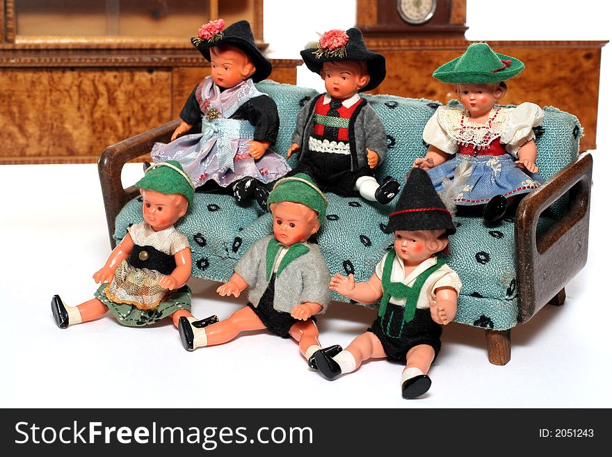 6 dolls in traditional European (I think they are Austrian but not sure) dresses sitting on a couch (old hand made furniture) with racks on the background. 6 dolls in traditional European (I think they are Austrian but not sure) dresses sitting on a couch (old hand made furniture) with racks on the background.