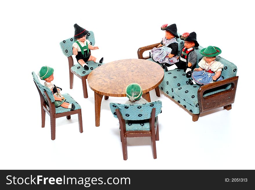 6 dolls in traditional European (I think they are Austrian but not sure) dresses sitting on chairs and couch round a table (old hand made furniture). 6 dolls in traditional European (I think they are Austrian but not sure) dresses sitting on chairs and couch round a table (old hand made furniture).