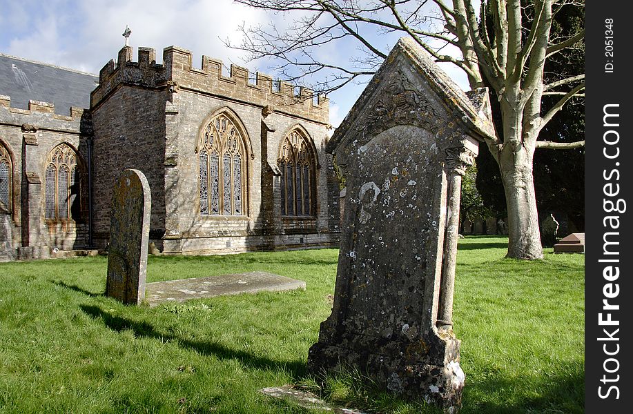 Medieval English Village Church with Headstones in the foreground. Medieval English Village Church with Headstones in the foreground