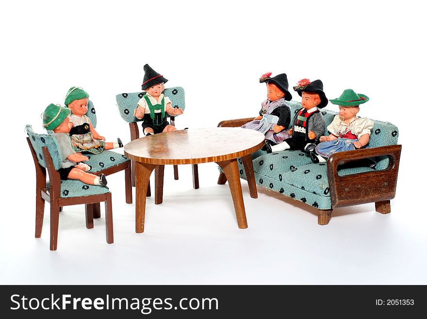 6 dolls in traditional European (I think they are Austrian but not sure) dresses sitting on chairs and couch round a table (old hand made furniture). 6 dolls in traditional European (I think they are Austrian but not sure) dresses sitting on chairs and couch round a table (old hand made furniture).