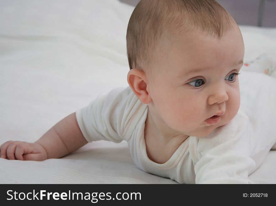 Blue eyed baby in bed.