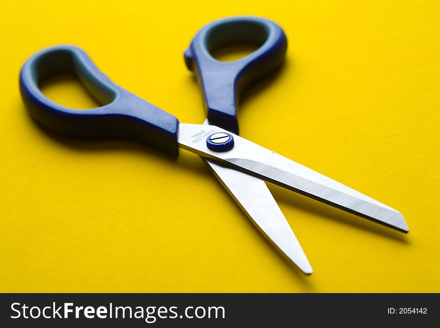 Open shears on blue background. Small DOF