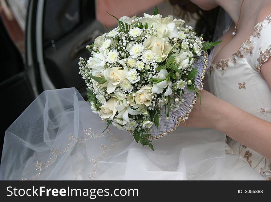 Wedding bouquet in a hand of the bride in wedding car. Wedding bouquet in a hand of the bride in wedding car