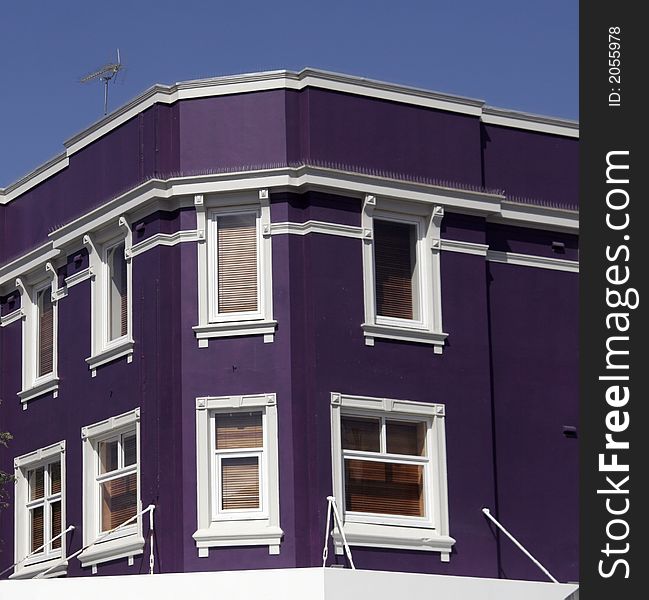 Purple, Violet Facade With White Windows, Urban Corner Building. Purple, Violet Facade With White Windows, Urban Corner Building