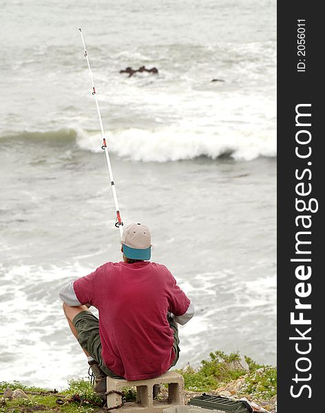 A man fishing in the surf along the California coast