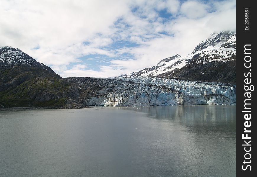 Image of Alaskan glacier surrounded by water sky and rock. Image of Alaskan glacier surrounded by water sky and rock