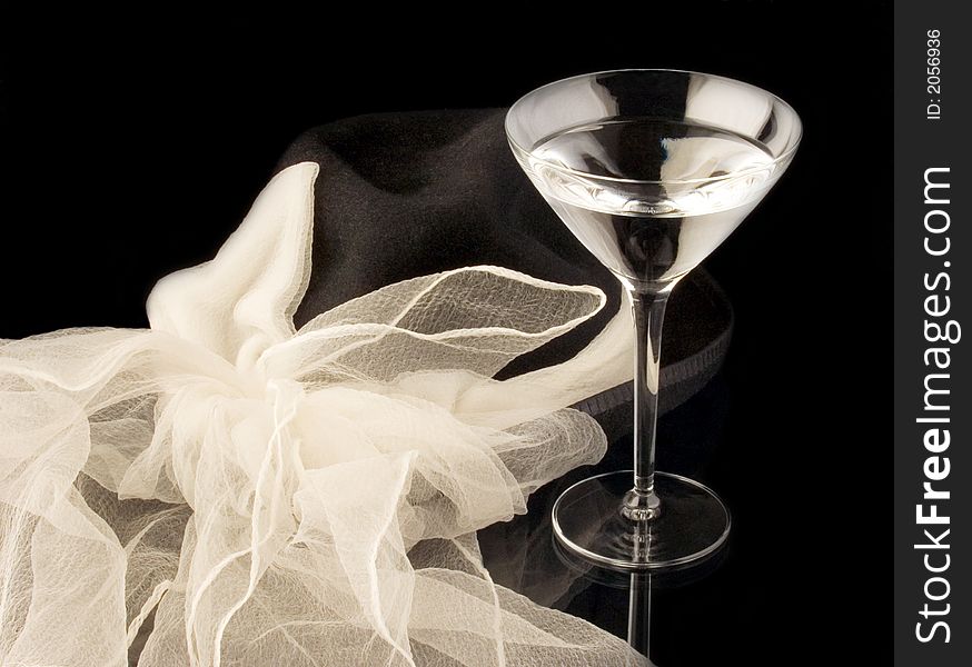 Black hat with white bow next to a Glass of Martini. Black hat with white bow next to a Glass of Martini