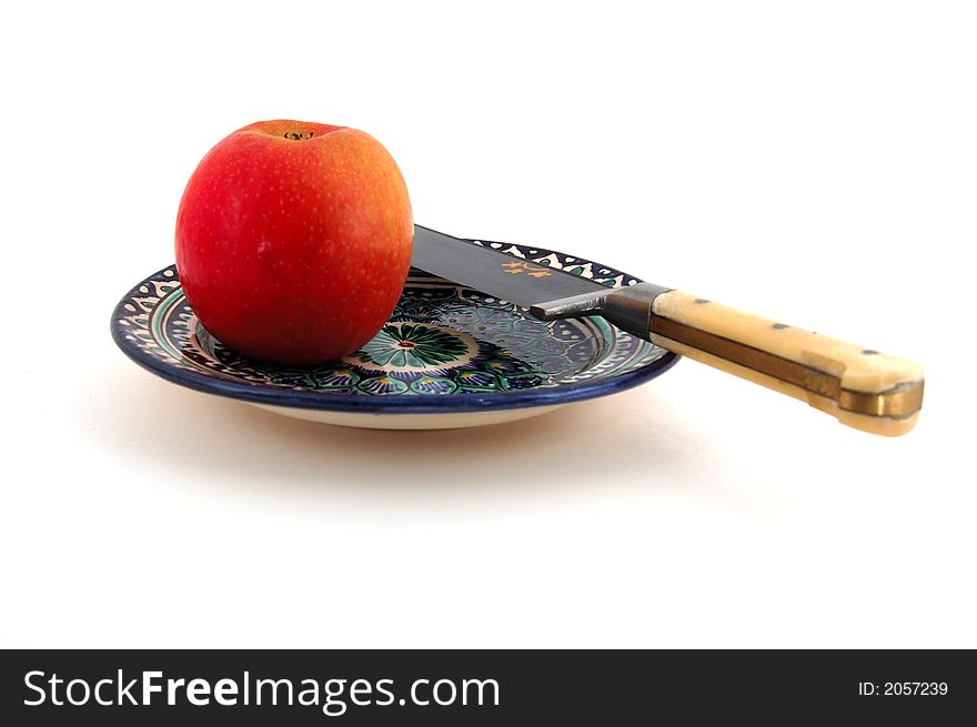 Isolated photo of Central Asian (Uzbek) desert plate with apple and traditional knife. Isolated photo of Central Asian (Uzbek) desert plate with apple and traditional knife.