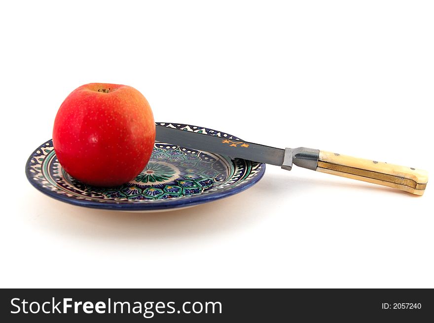 Isolated photo of Central Asian (Uzbek) desert plate with apple and traditional knife. Isolated photo of Central Asian (Uzbek) desert plate with apple and traditional knife.