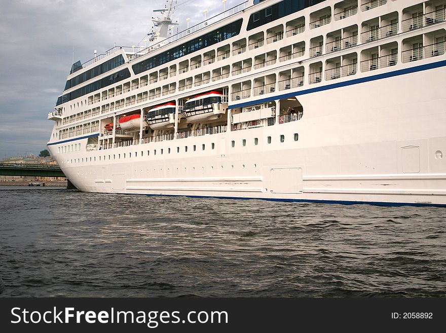 Ocean liner at St. Petersburg's port in the summer evening. Clouded skies and calm water.