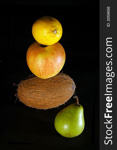 Fruits on black - pear, apple, lemon, coconut