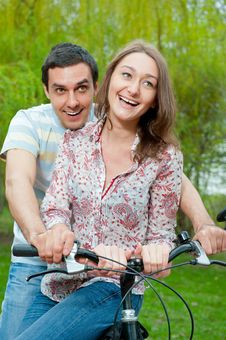 Happy Young Couple Riding Bicycle Stock Photography