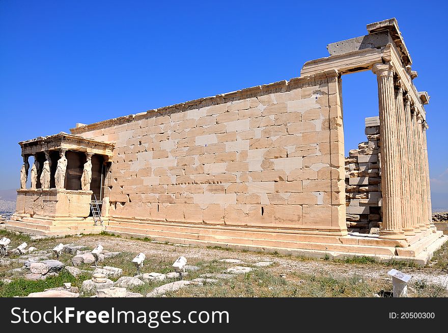 Erechtheion on blue sky background - part of Acropolis in Athens. Full view.
